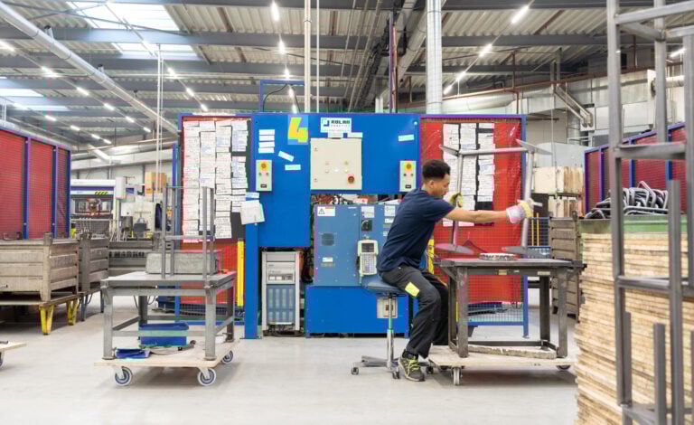 Een industrieomgeving waar iemand aan een tafel werkt met een industriekruk